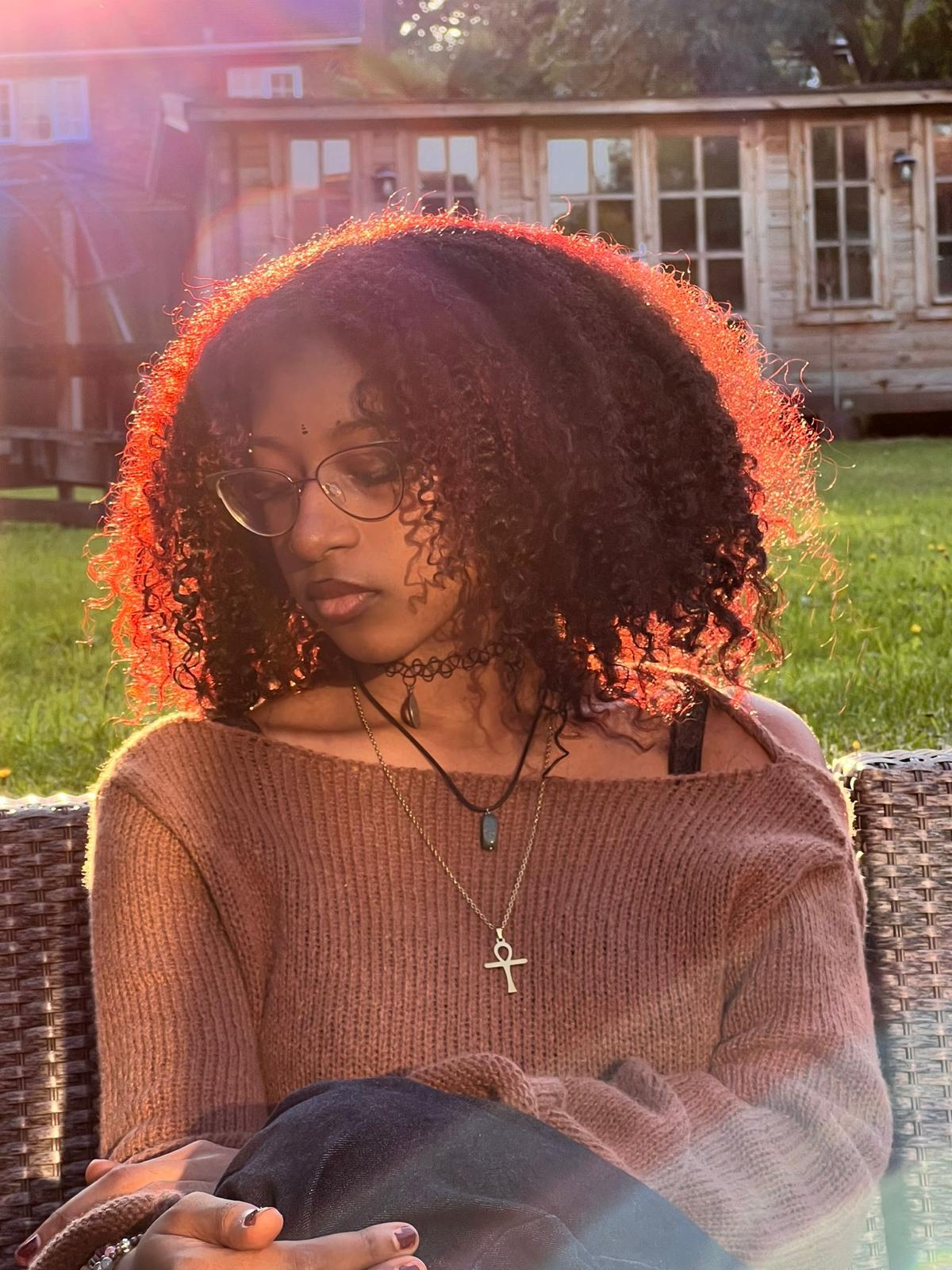 Alanna Crouch seated outdoors in warm garden light.