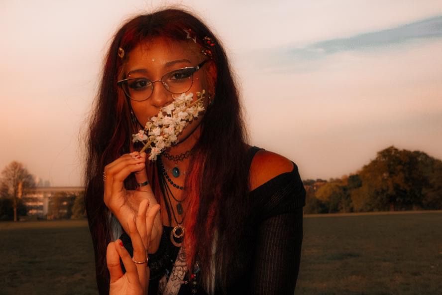 Alanna Crouch holding white blossoms in warm evening light.